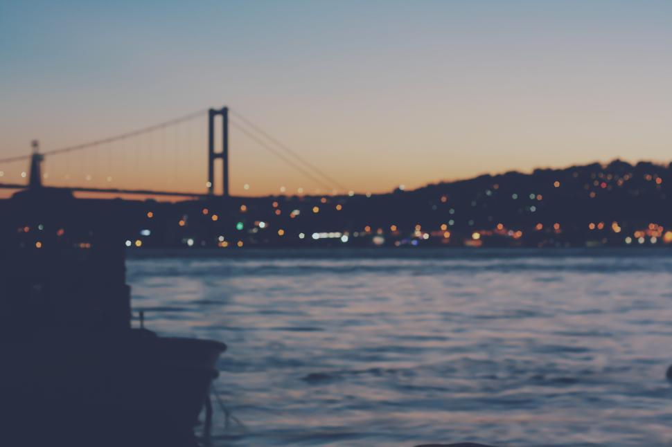 Free Image of Sunset view over the water near a bridge in Lisbon 