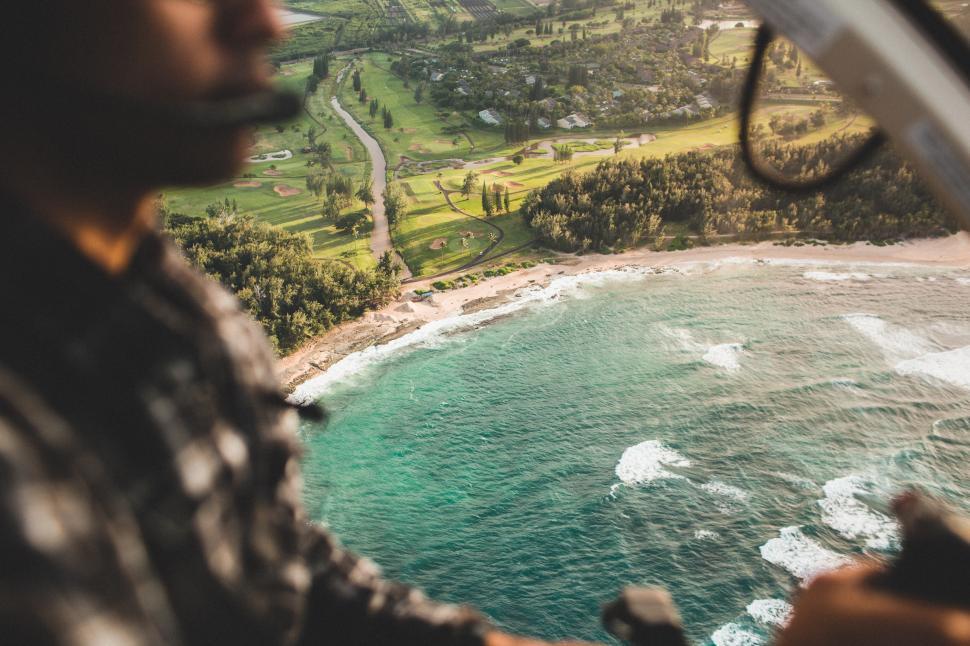 Free Image of Scenic coastline view from a helicopter over lush green landscape at dusk 