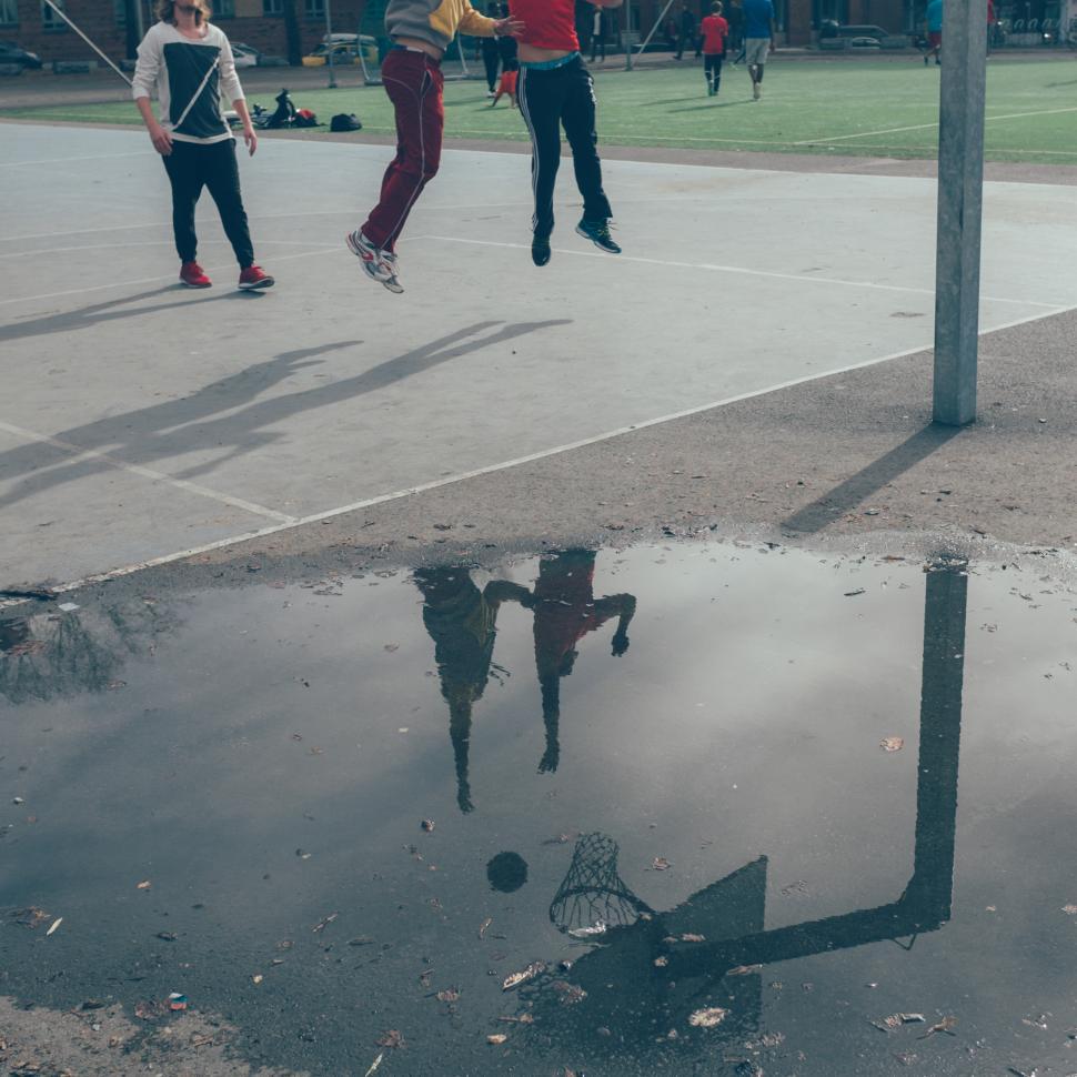 Free Image of Jumping children reflect in puddle during outdoor play 