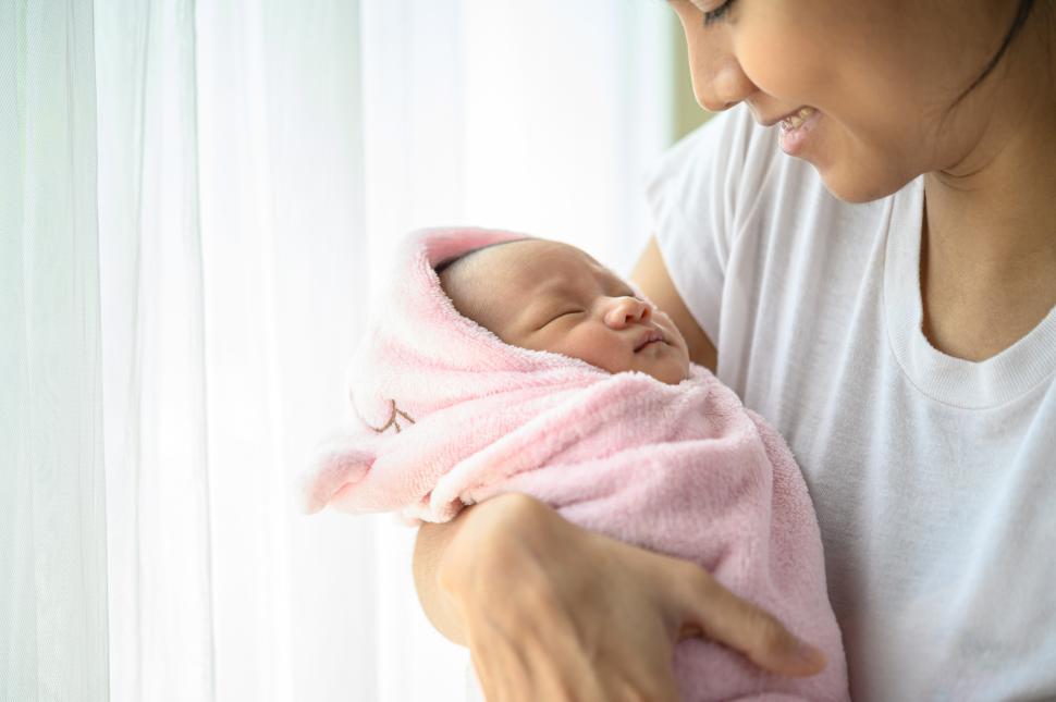 Free Image of The newborn baby sleeping in the embrace of the mother. 