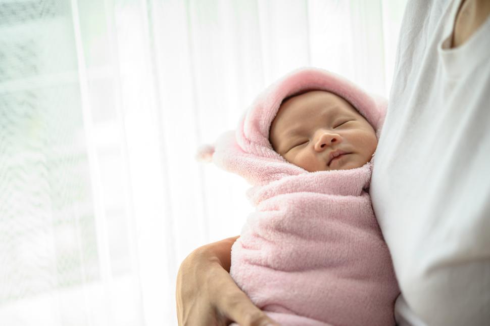 Free Image of The newborn baby sleeping in the embrace of the mother. 