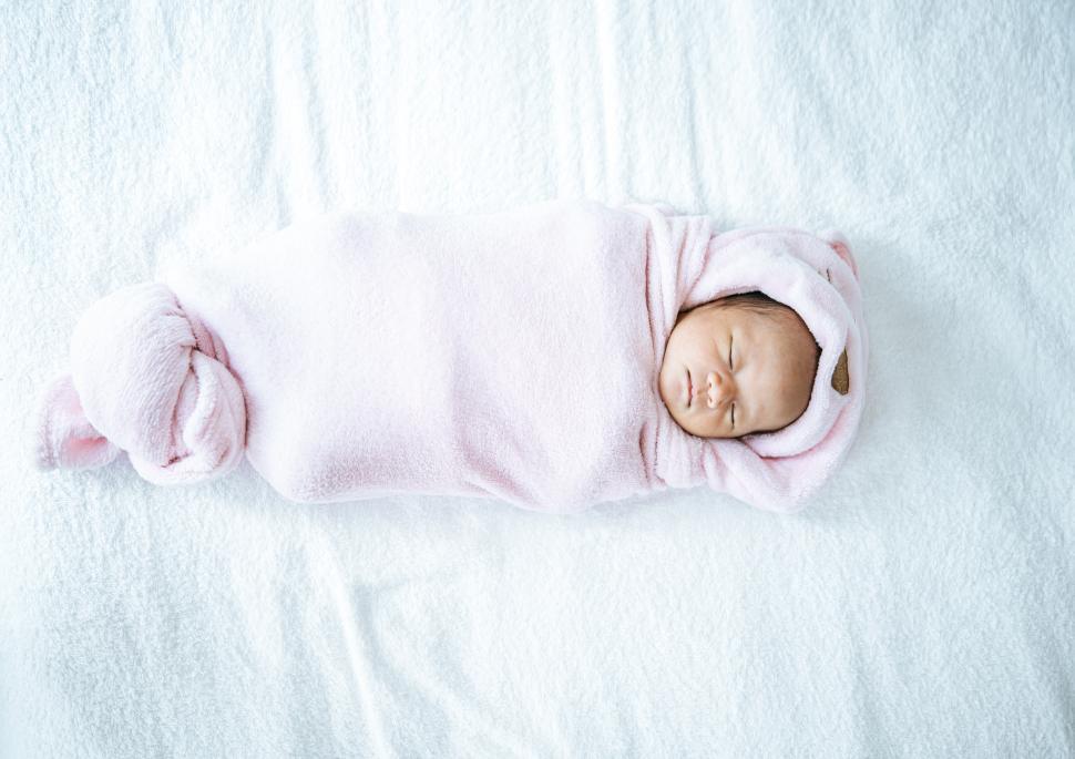 Free Image of Newborn baby sleeping on a soft pink blanket. 
