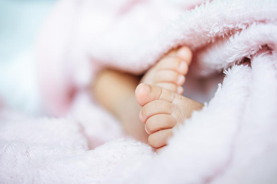 Free Image of Newborn baby feet on a white blanket. 