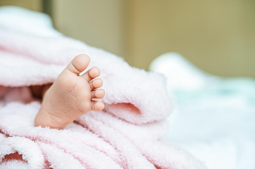 Free Image of Newborn baby feet on a white blanket. 