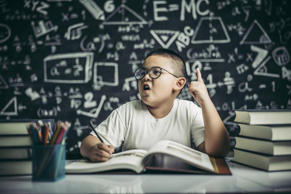 Free Image of Boys with glasses write books and think in the classroom 