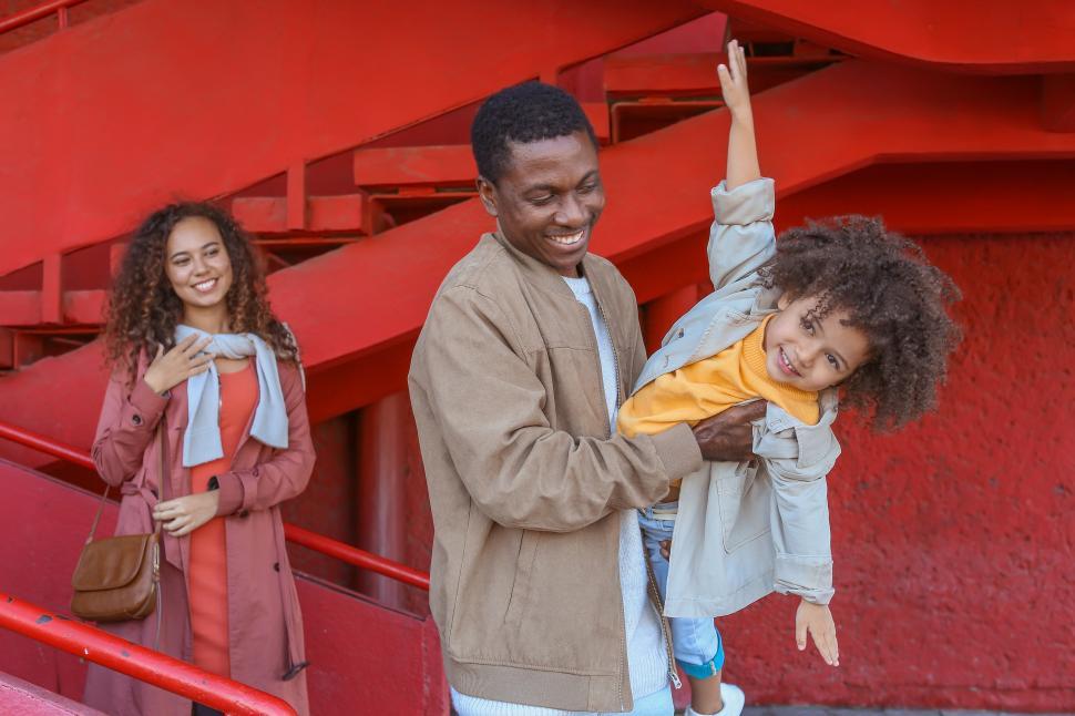 Free Image of Family enjoying playful moments on vibrant red stairs in urban setting 