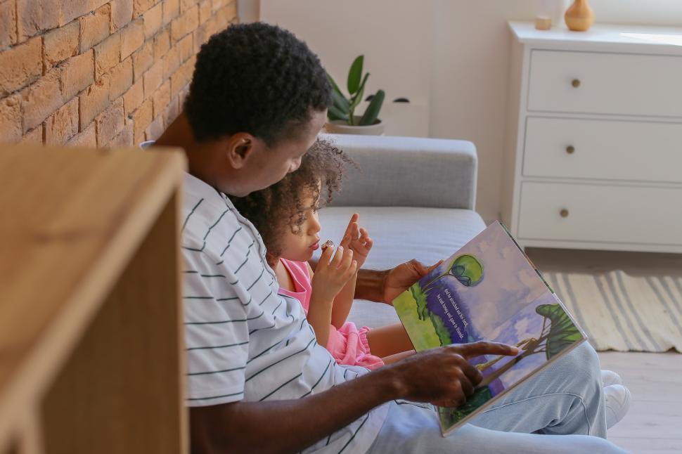 Free Image of Father and daughter enjoy reading together in a cozy living room 