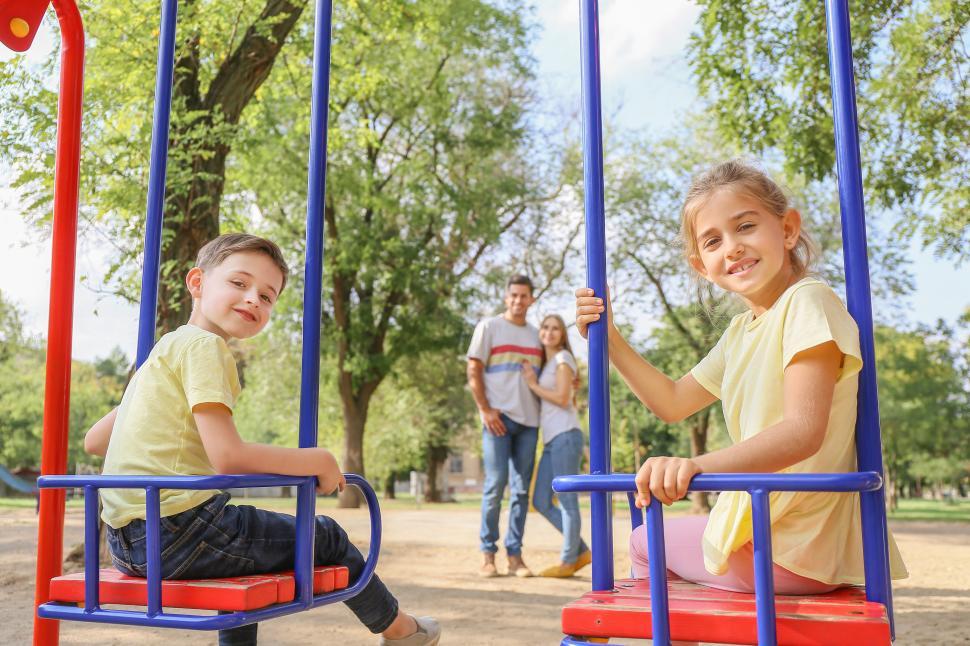 Free Image of Children enjoy swinging in a park on a sunny day 