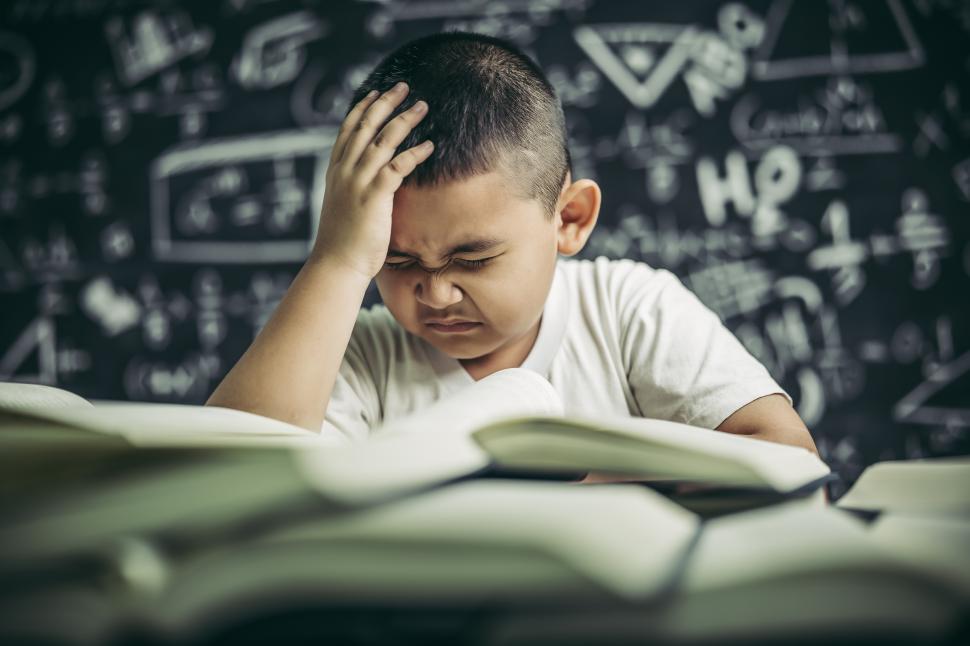 Free Image of Boys with glasses write books and think in the classroom 