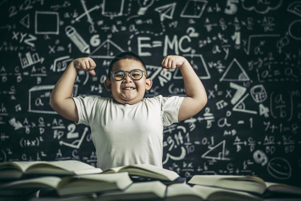 Free Image of A boy with glasses sitting in the study and with both arms perpendicular 