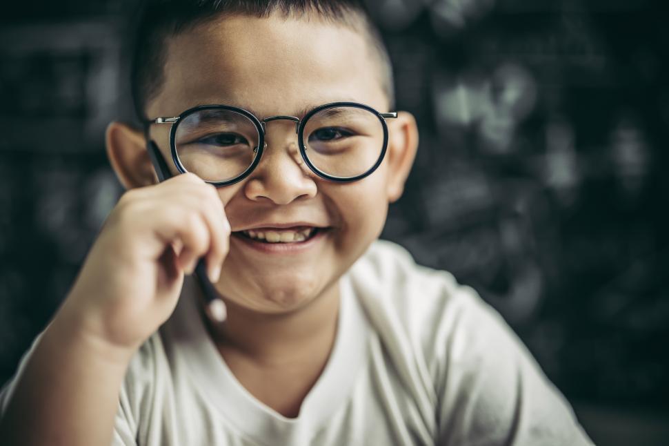 Free Image of A boy with glasses sitting in the classroom studying 