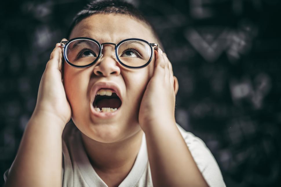 Free Image of Boy with glasses frustrated in the classroom 