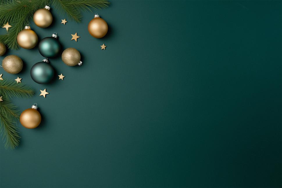 Free Image of Festive holiday decorations with ornaments and evergreen branches on dark backdrop 