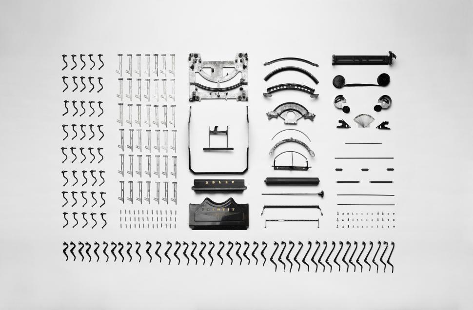 Free Image of Assembly of various mechanical typewriter parts organized neatly on a white background 