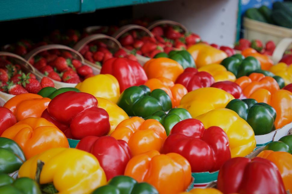 Free Image of Colorful peppers and strawberries at a market stand 