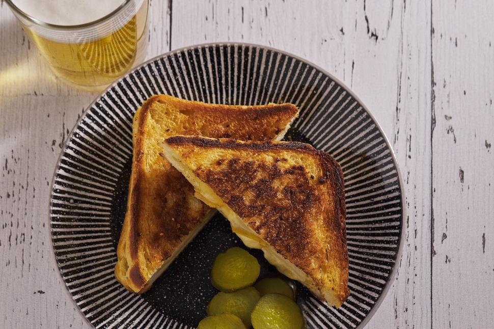 Free Image of Delicious grilled cheese sandwich with pickles and beer 
