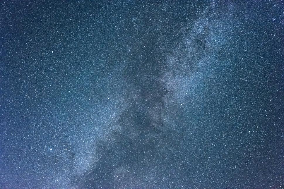 Free Image of Bright stars fill the night sky over a tranquil landscape 