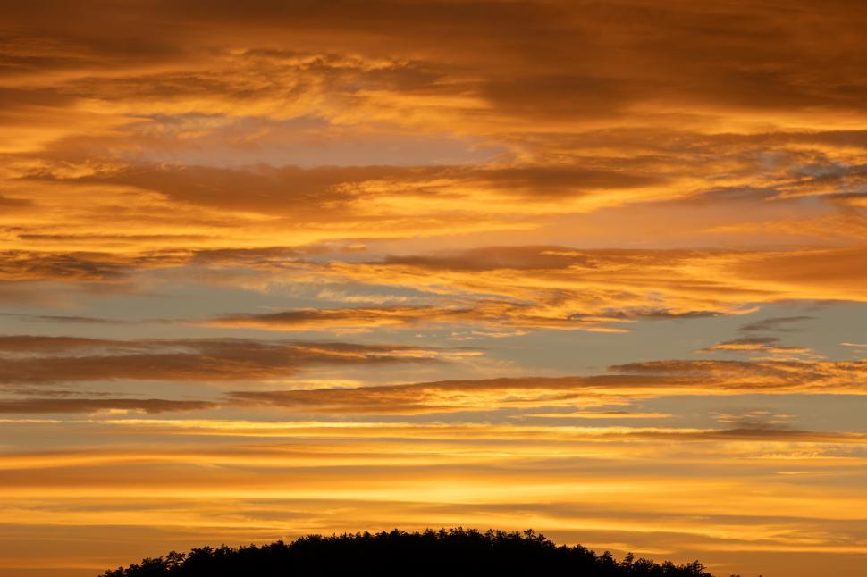 Free Image of Colorful sunset with vibrant clouds over the hills 