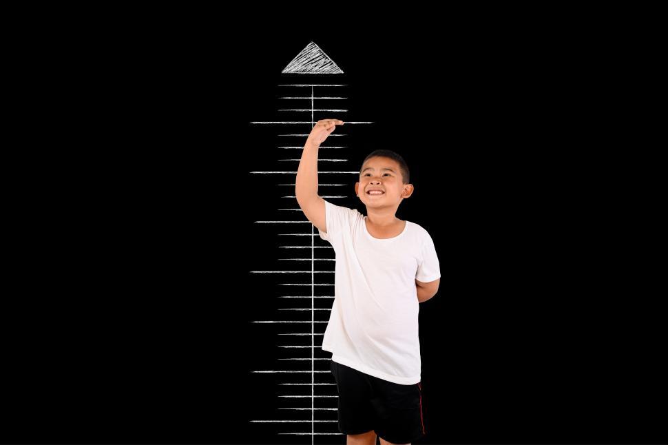 Free Image of The boy measured the height with the blackboard 