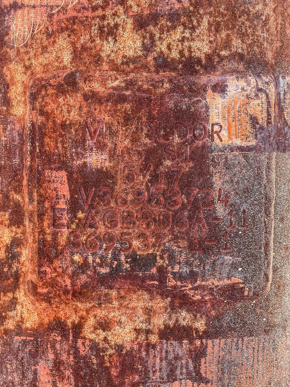 Free Image of Rusty metal plate with engraved markings found in an outdoor setting 