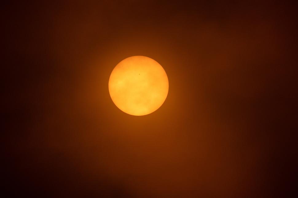 Free Image of Bright sun shining through a hazy sky at sunset 