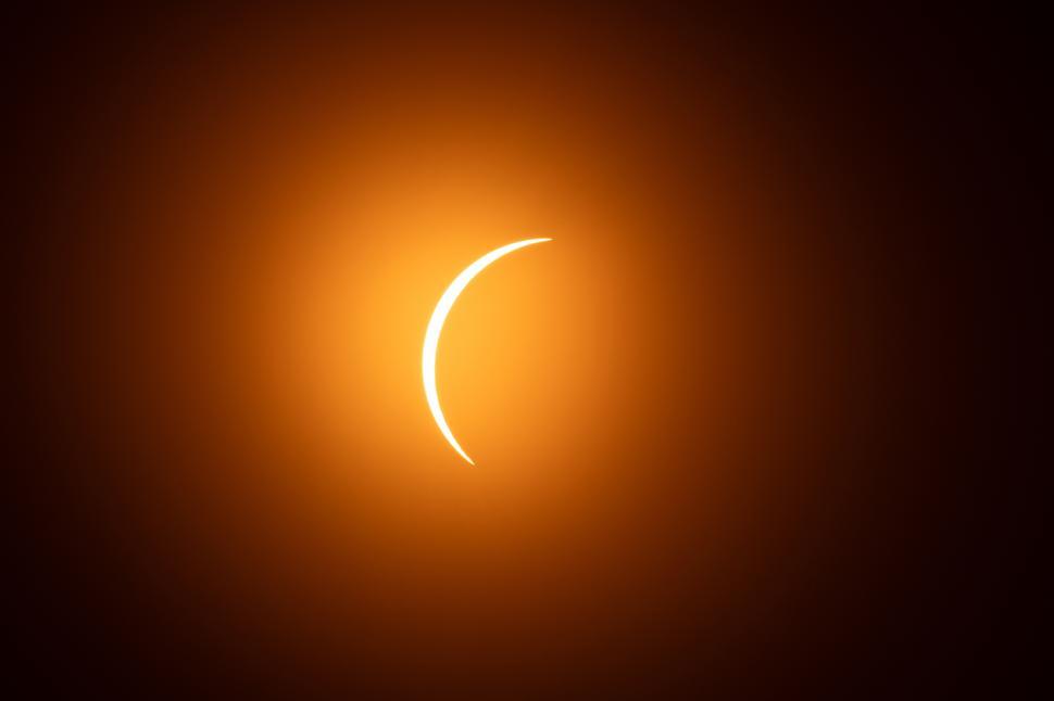 Free Image of Solar eclipse occurring in a clear sky above a landscape 