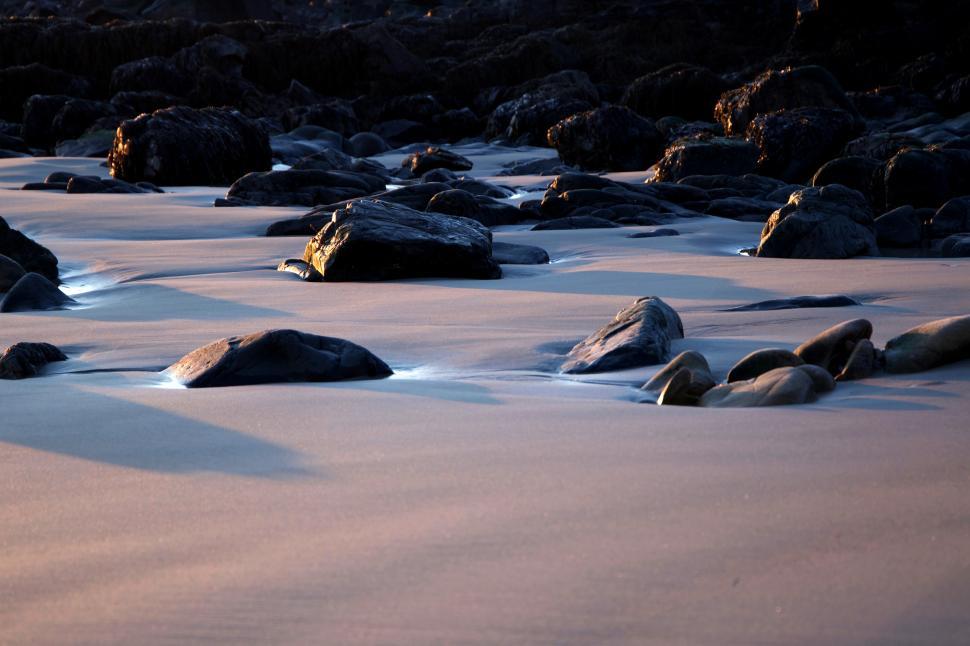 Free Image of Serene beach landscape with smooth rocks at sunset 