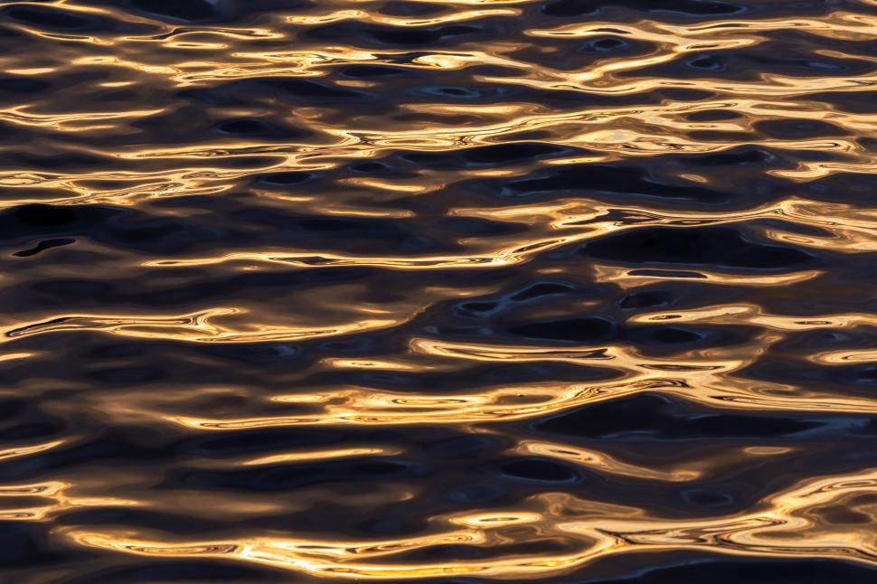 Free Image of Beautiful golden reflections on water surface at sunset 