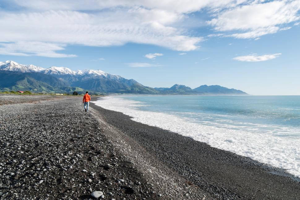 Free Image of Walking along the black pebble beach near mountains 