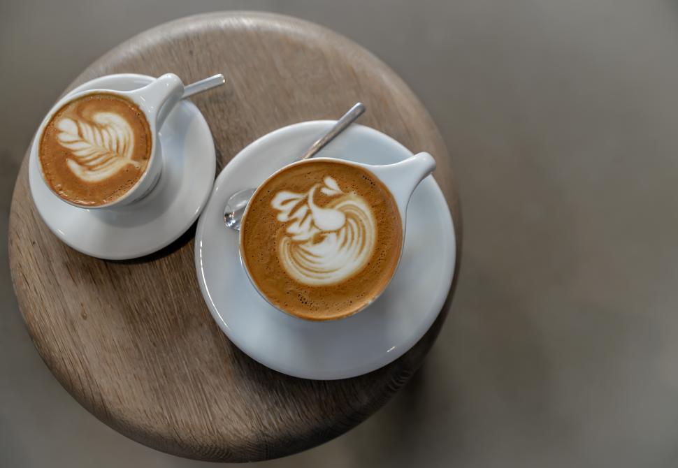 Free Image of Cozy coffee cups with latte art on a wooden table 