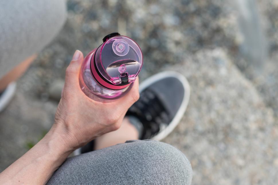 Free Image of Holding a water bottle during a relaxing outdoor break 