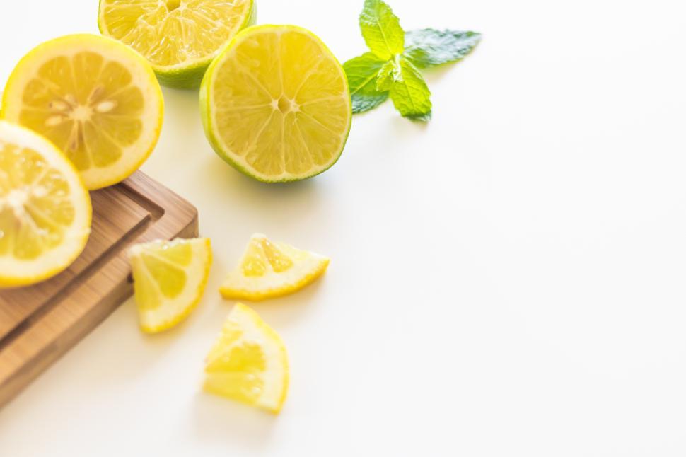 Free Image of Freshly cut lemons and limes arranged on a cutting board 
