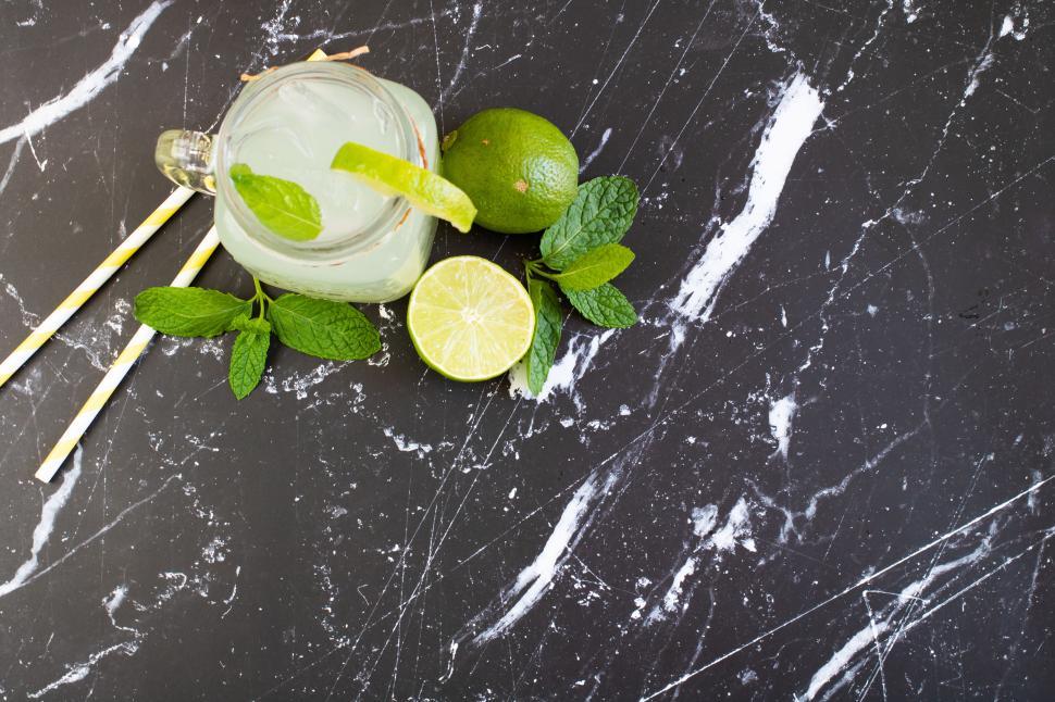 Free Image of Refreshing mint and lime beverage on a marble surface during sunny afternoon 