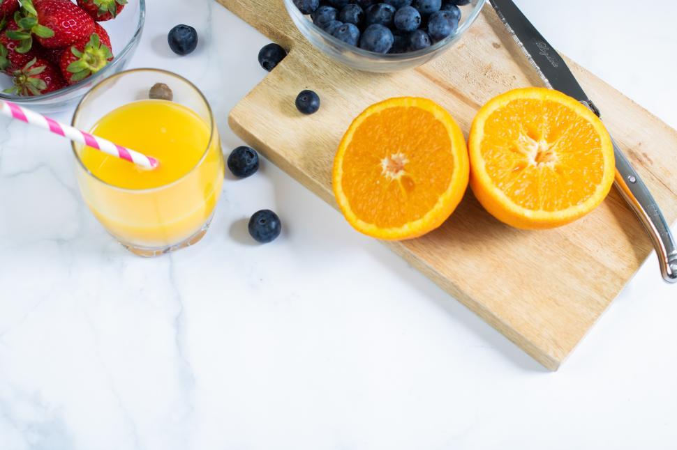 Free Image of Fresh fruit preparation on a kitchen counter with juice 