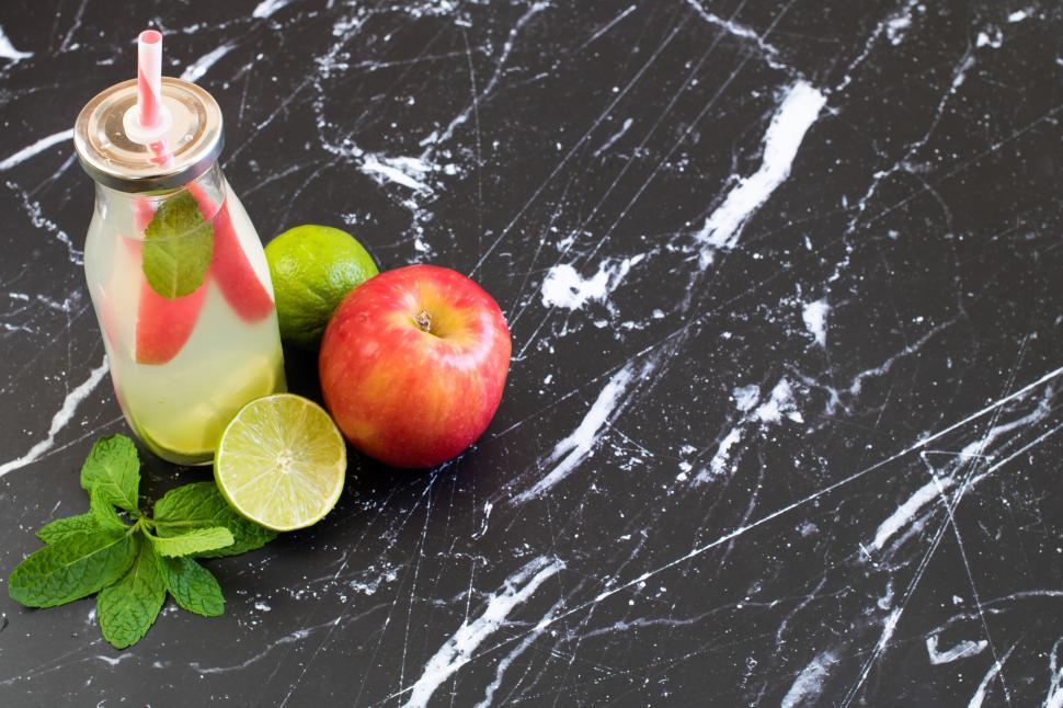 Free Image of Refreshing drink with apple and lime on marble table 