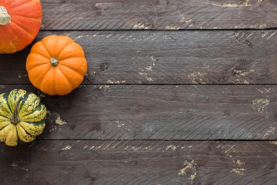 Free Image of Colorful pumpkins arranged on a rustic wooden table 