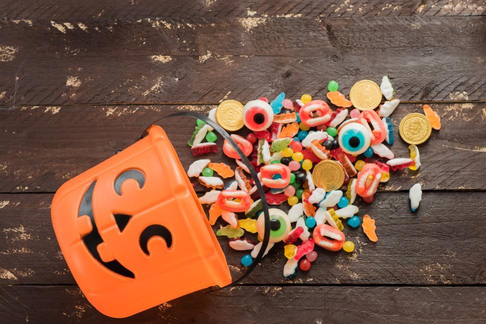 Free Image of Halloween bucket spilling colorful candies and treats 