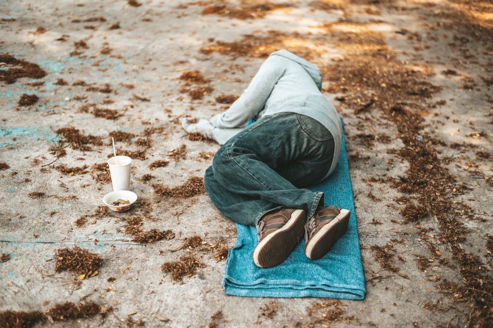 Free Image of Beggars lying on the side of the street with dirty clothes. 