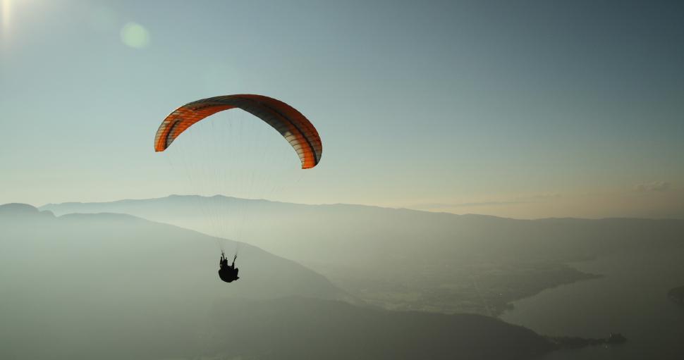 Free Image of Paraglider soaring above mountains at sunrise 