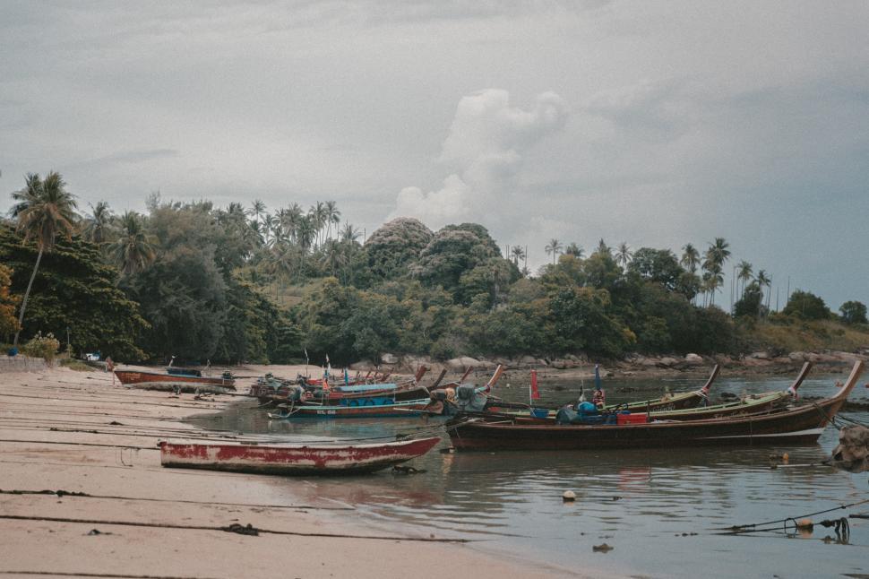 Free Image of Fishing boats rest on a quiet beach at low tide 