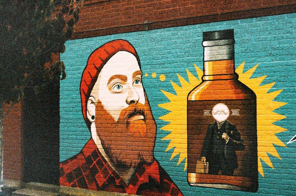 Free Image of Urban mural depicting a man dreaming of whiskey 