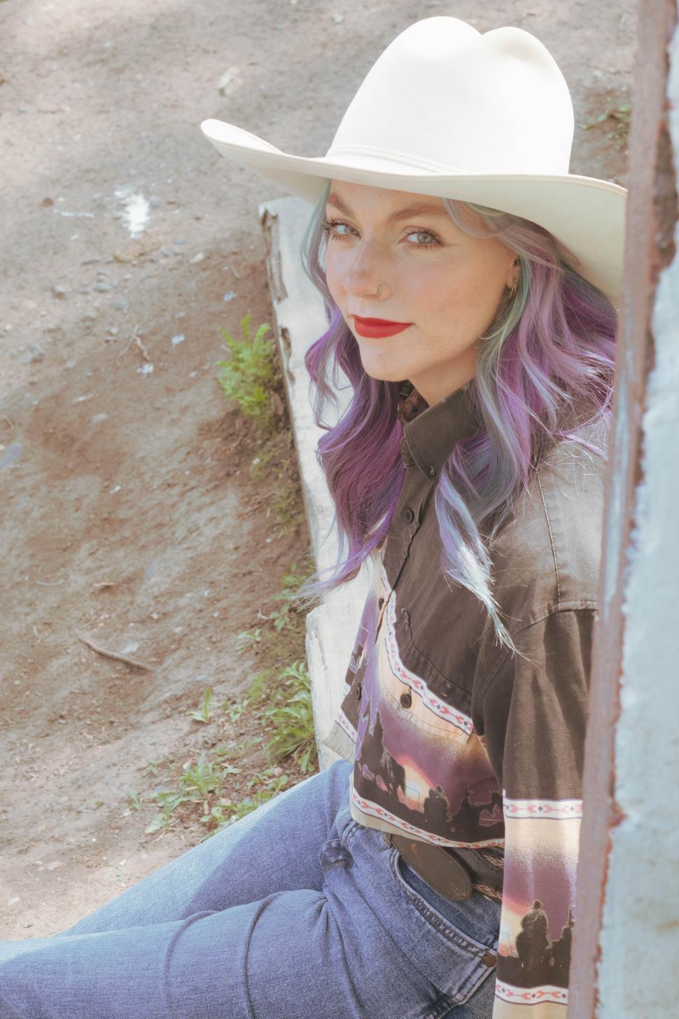 Free Image of Woman with colorful hair and cowboy hat at outdoor location during daytime 