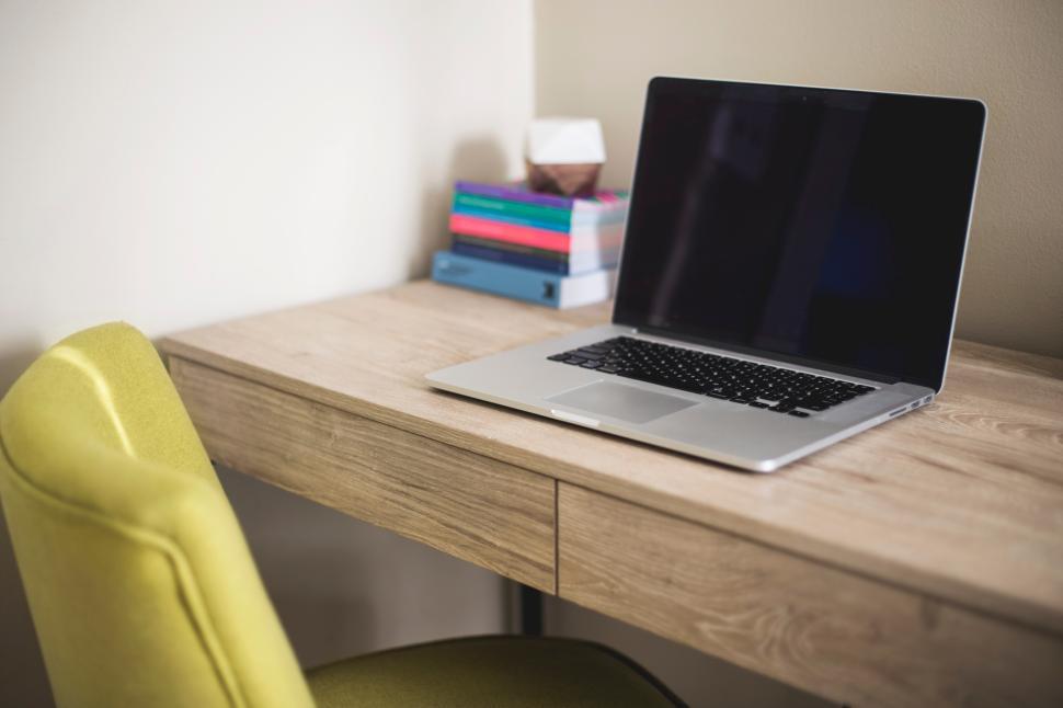 Free Image of Minimalist workspace with laptop and books on wooden desk 