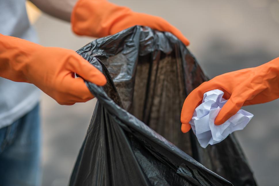 Free Image of Men and women help each other to collect garbage. 