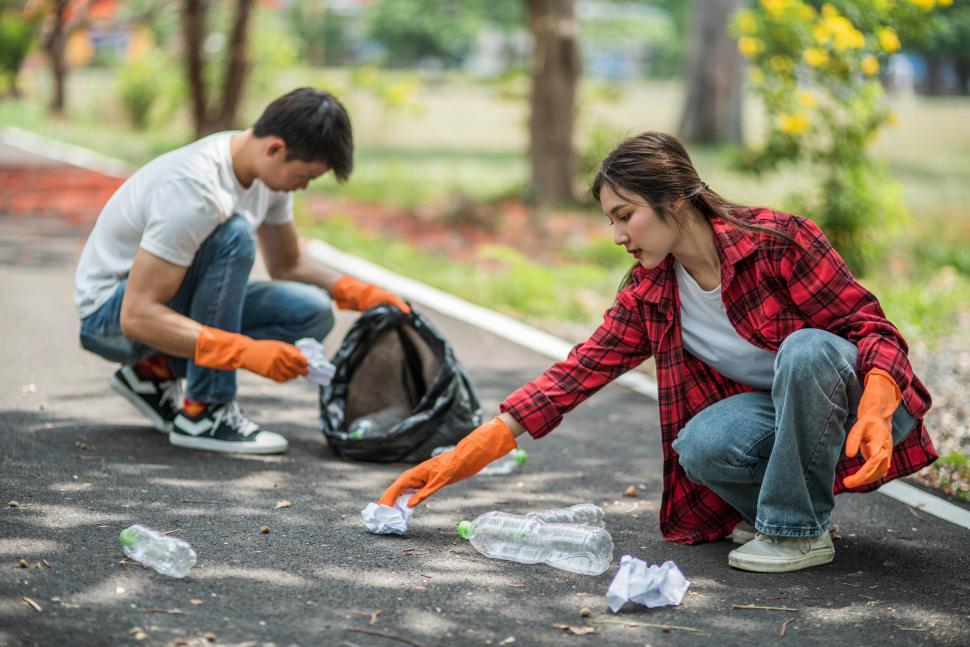 Free Image of Men and women help each other to collect garbage. 