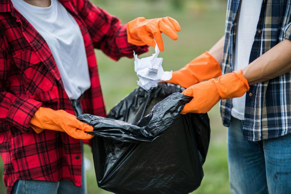 Free Image of Men and women help each other to collect garbage. 