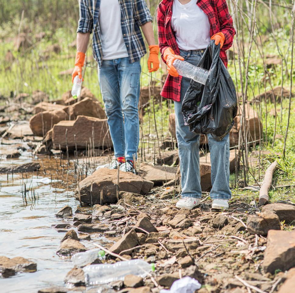 Free Image of Men and women help each other to collect garbage. 