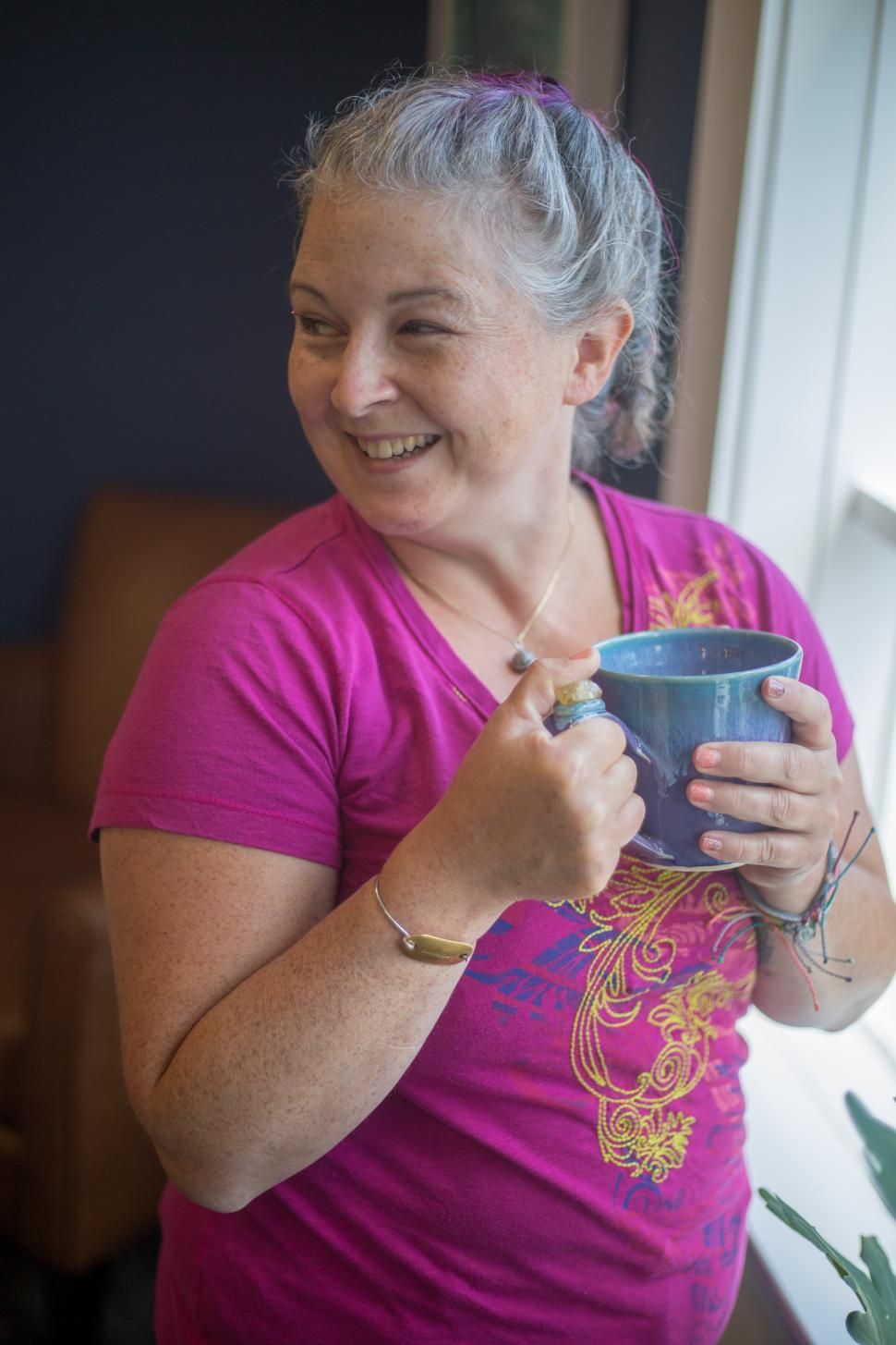 Free Image of Woman enjoys warm beverage while relaxing indoors 