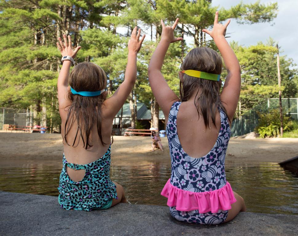 Free Image of Children enjoy summer fun by the lakeside, celebrating with joyful gestures 