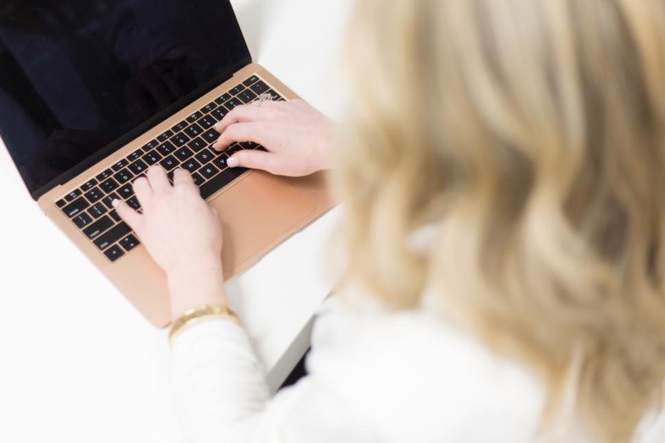 Free Image of Woman typing on a laptop at a stylish workspace 